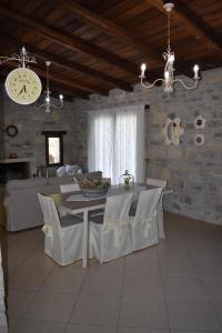 a living room with a table and chairs and a clock at Villa Arvi in Arvi