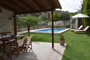 a patio with a table and chairs and a pool at Villa Arvi in Arvi