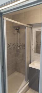 a bathroom with a shower with a sink and a mirror at Studio cabine à proximité des plages in Gruissan