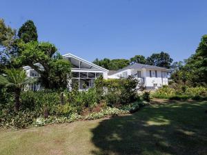 a white house with a garden in front of it at Ulifalodge whitehouse in Hillcrest