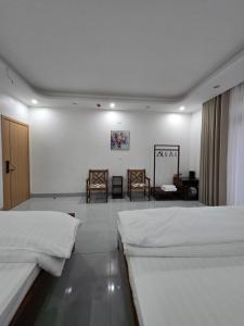 a bedroom with two beds and two chairs at Tam Coc Natura Hotel in Văn Lâm +31 photos