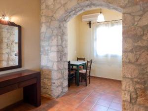 a dining room with a table and a stone wall at Mandilada Family Village - Seaview Villas in Marathokampos