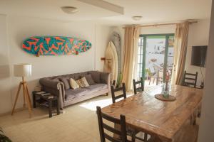 a living room with a table and a couch at Vivilanza Surfhouse in Costa Teguise
