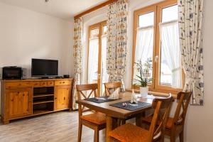 a dining room with a table and a television at Ferienwohnungen Ruasers Ruah in Mittenwald