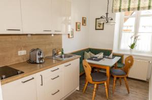 a kitchen with a sink and a table with chairs at Ferienwohnungen Ruasers Ruah in Mittenwald