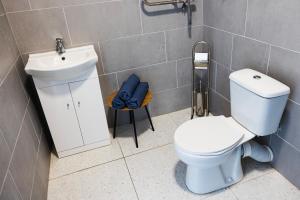 a bathroom with a white toilet and a sink at ROOMS Park in Skuodas