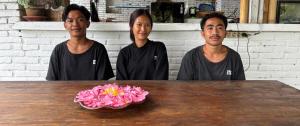 three men standing in front of a table with a bowl of flowers at Lombok Coconut Hotel in Mangsit +40 photos