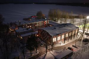 a large building with lights on in the snow at Hotel Mezaparks in Riga