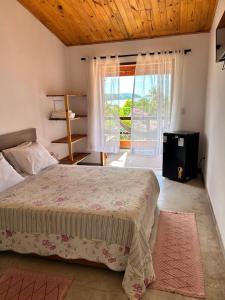 a bedroom with a bed and a large window at Pousada Tribo Do Sol in Ubatuba +43 photos