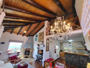 a living room with wooden ceilings and a chandelier at Boutique Chalet in Calheta in Arco da Calheta