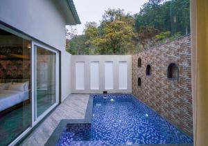 a swimming pool in the middle of a house at Vanasya Retreat Corbett in Amgarhi