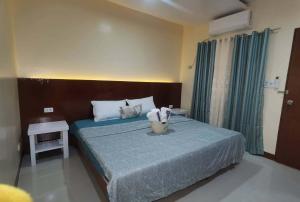 a bedroom with a bed with a blue comforter at Little Haven at Lio in El Nido