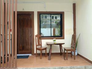 a room with a table and two chairs and a window at Little Haven at Lio in El Nido