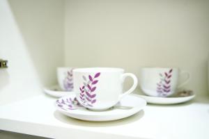 three cups and saucers sitting on a shelf at Apartman VIK in Brzeće