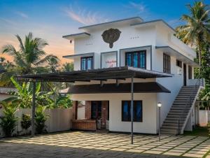 a white house with a roof at Rajadhani Apartment in Karunāgapalli