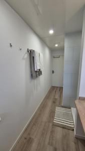 a room with white walls and a hallway with a rug at Studio Margny in Margny