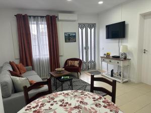 a living room with a couch and a tv at Nunes Praia in Praia da Vitória