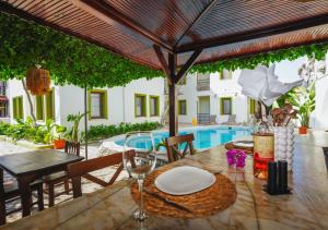 an outdoor table with a table umbrella and a pool at The Dalyan's in Dalyan