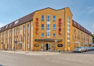 ein großes Backsteingebäude mit einem Hotelschild darauf in der Unterkunft Hotel Märkischer Hof in Luckenwalde