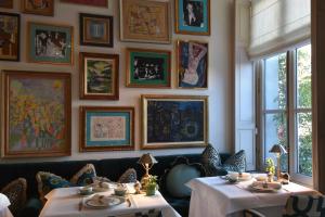 a dining room with two tables and pictures on the wall at Hotel Van Cleef in Bruges