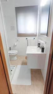 a white bathroom with a toilet and a sink at Voglio Vivere Così in Santo Stefano di Magra