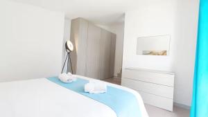 a white bedroom with a bed and a dresser at Voglio Vivere Così in Santo Stefano di Magra