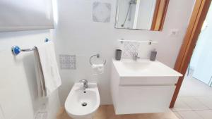 a white bathroom with a sink and a toilet at Voglio Vivere Così in Santo Stefano di Magra +3 photos