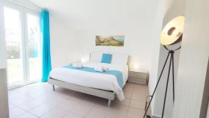 a bedroom with a bed and a floor lamp at Voglio Vivere Così in Santo Stefano di Magra