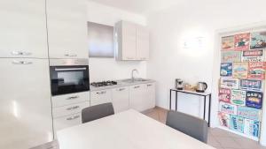 a kitchen with white cabinets and a table with chairs at Voglio Vivere Così in Santo Stefano di Magra