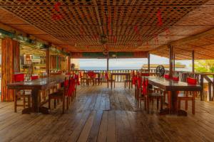 a restaurant with wooden tables and red chairs at Anda De Boracay White Sand Resort in Anda