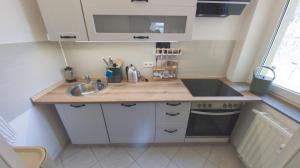 a small kitchen with a sink and a stove at Ferienwohnung Stadtblick Königstein in Königstein an der Elbe +20 photos