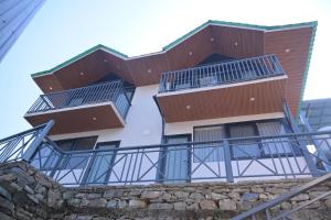 a building with balconies on top of a stone wall at Alpine Vista Wellness & Resort in Gupta Kāshi