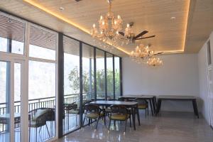 a dining room with tables and chairs and a chandelier at Alpine Vista Wellness & Resort in Gupta Kāshi +26 photos