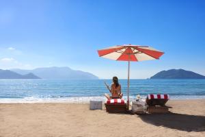 a woman sitting on the beach under an umbrella at XO CAPE ARNNA Fethiye in Fethiye +230 photos
