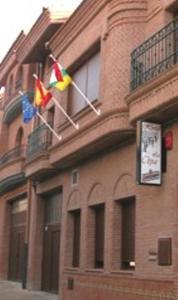 duas bandeiras na lateral de um edifício de tijolos em Hostal la Cepa em Aldeanueva de Ebro
