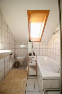a bathroom with a tub and a sink and a toilet at Helle Ferienwohnung im Schwarzwald - 2 Schlafzimmer - WLAN - Holzapfel Apartments in Villingen-Schwenningen