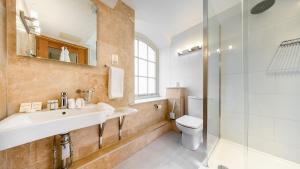 a bathroom with a sink and a toilet and a shower at Ennios Boutique Hotel in Southampton