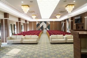 a conference room with white chairs and red seats at Highland Hotel in Bangalore