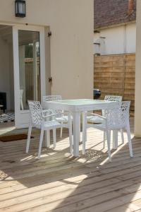 a white table and chairs on a patio at Les Mimosas in Ronce-les-Bains