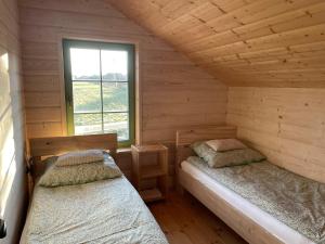 a bedroom with two beds in a log cabin at Dom Galicja in Radziechowy