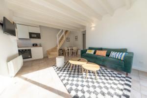 a living room with a green couch and a table at Les Mimosas in Ronce-les-Bains