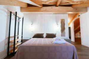 a bedroom with a bed with two towels on it at Blue House Ponte de Lima in Ponte de Lima
