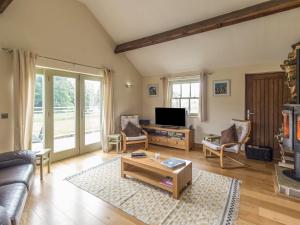 a living room with a couch and a tv at Orchard Cottage in Durham