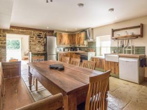 a large kitchen with a wooden table and chairs at Orchard Cottage in Durham