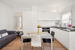 a kitchen and a dining room with a table and chairs at Apartamento Sa Mesquida 9 by 3VILLAS in Cala Llonga