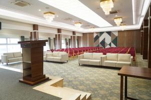 a conference room with white chairs and a podium at Highland Hotel in Bangalore