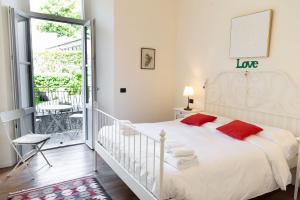 a bedroom with a white bed with red pillows at Casa Julia - Menaggio by LoveComo in Menaggio +15 photos
