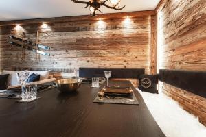 a dining room with a table and a wooden wall at StAnton Snow in Sankt Anton am Arlberg