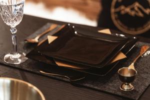 a black plate on a table with a wine glass at StAnton Snow in Sankt Anton am Arlberg +26 photos