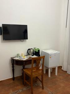 a room with a table with a television on a wall at B&B Mirabella Rooms Ortigia in Syracuse +35 photos